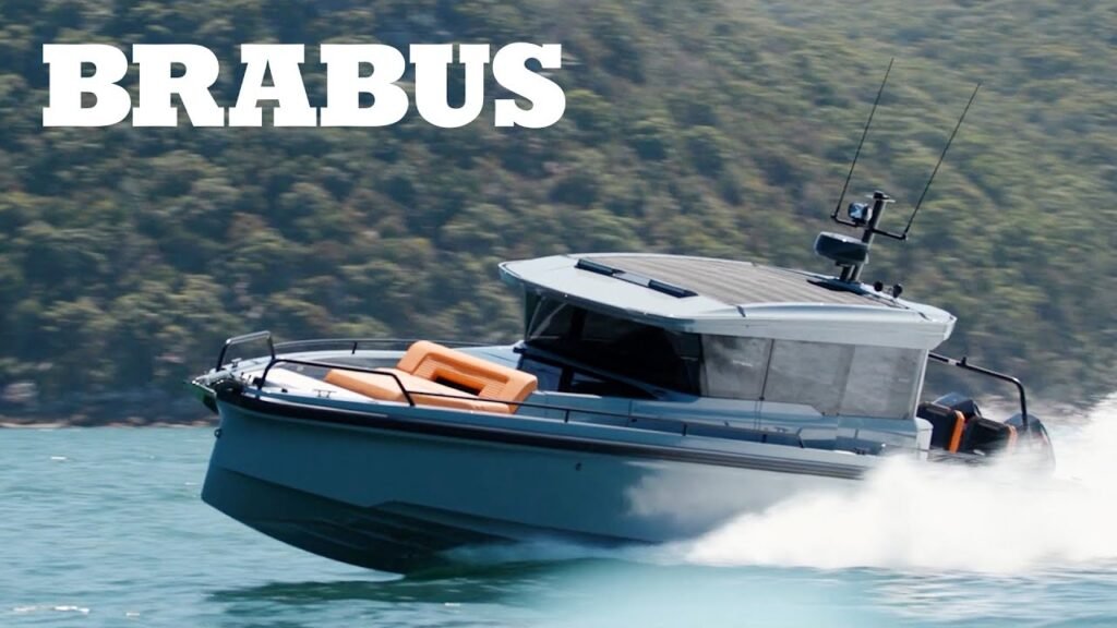 A gray and black Brabus 800 Adventure XLP, an off-road pickup truck conversion of a Mercedes-Benz G-Class, shown in a snowy mountain landscape, featuring large all-terrain tires, a roof rack with lights, and a front winch.