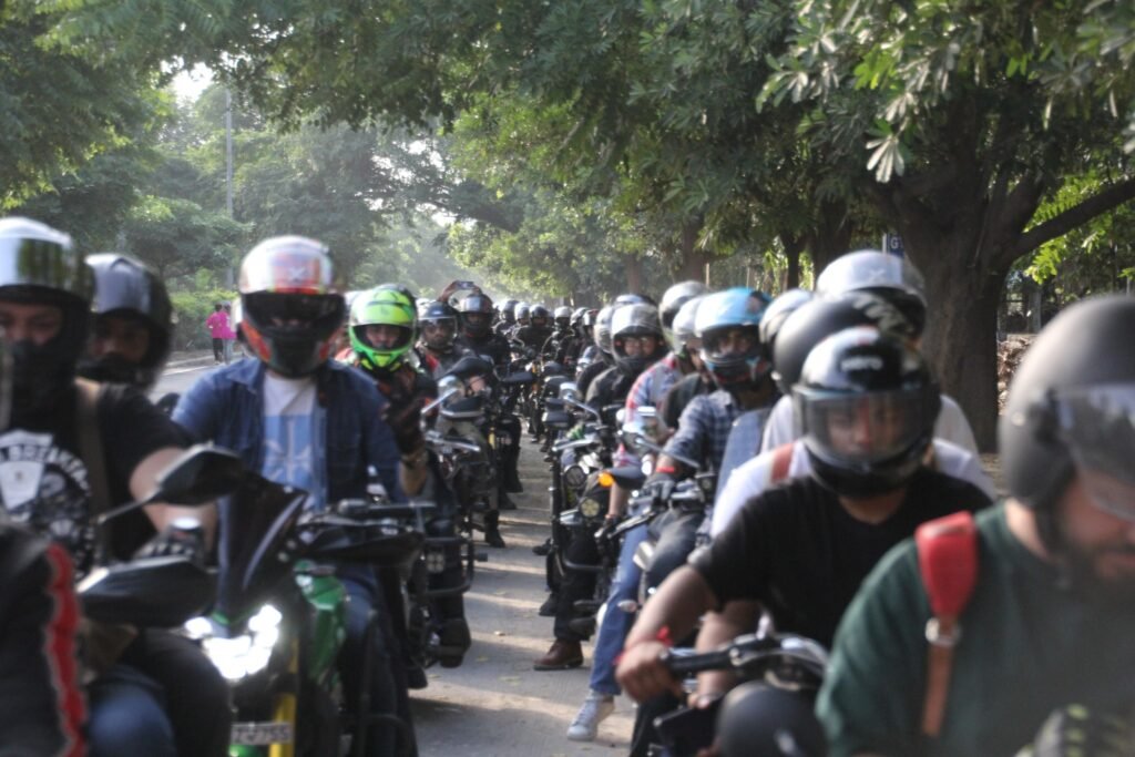 
A large convoy of fully geared riders from the DBBR biker group riding together in a column on a tree-lined road during a morning group ride.