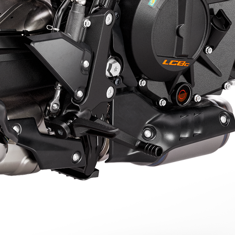 
Close-up view of the black rider footpeg, shift lever, and the LC8c engine case of the KTM Duke 990.