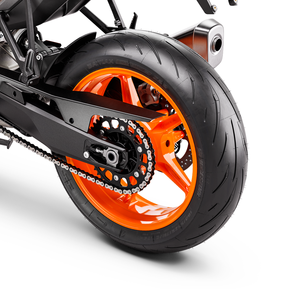 
Bright orange rear wheel and swingarm of a KTM Duke 990 motorcycle, showing the tire, chain, and sprocket.