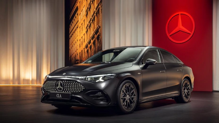 2025 Mercedes CLA showcased in a premium studio setting with a matte black finish, featuring its new grille design and sleek coupe-style body.